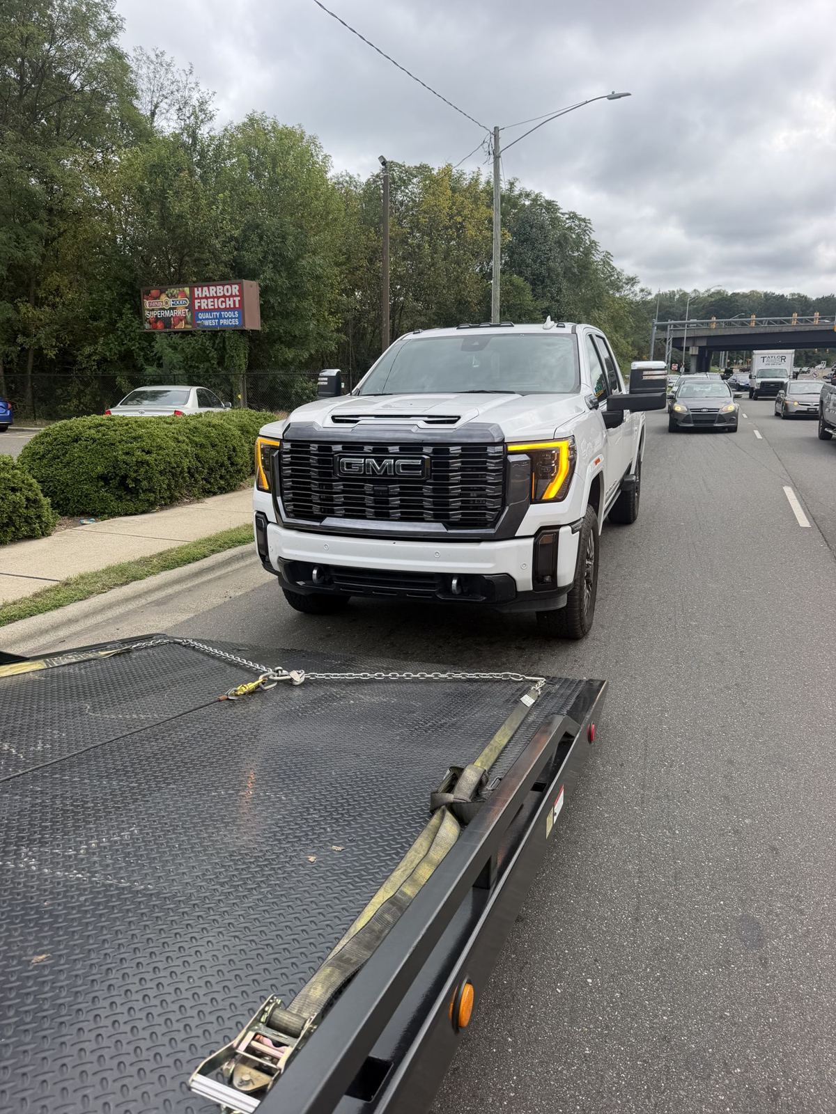 GMC pickup lined up behind a lowered rollback bed on the roadside